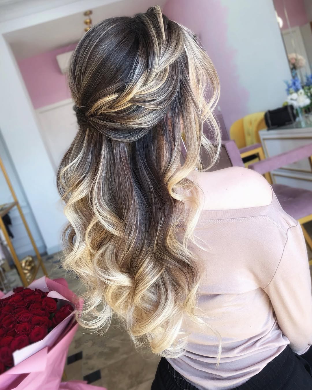 Woman with effortless summer hairstyle 2026, featuring loose waves cascading over a white and blue striped tank top, perfect for a casual beach day or outdoor brunch.