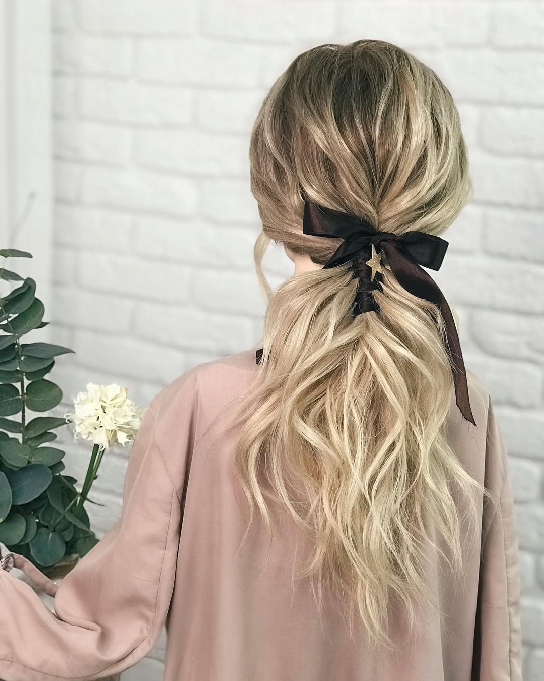 Close-up of a woman with an effortless summer hairstyle, featuring loose, beachy waves and a soft, natural makeup look perfect for a casual day out.