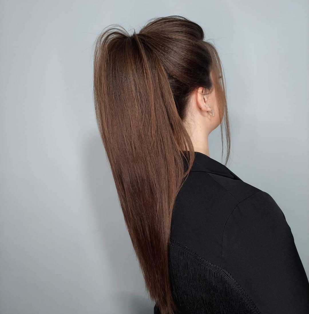 Blonde woman with a messy bun, demonstrating an effortless summer hairstyle for 2026, perfect for casual outings or beach days.