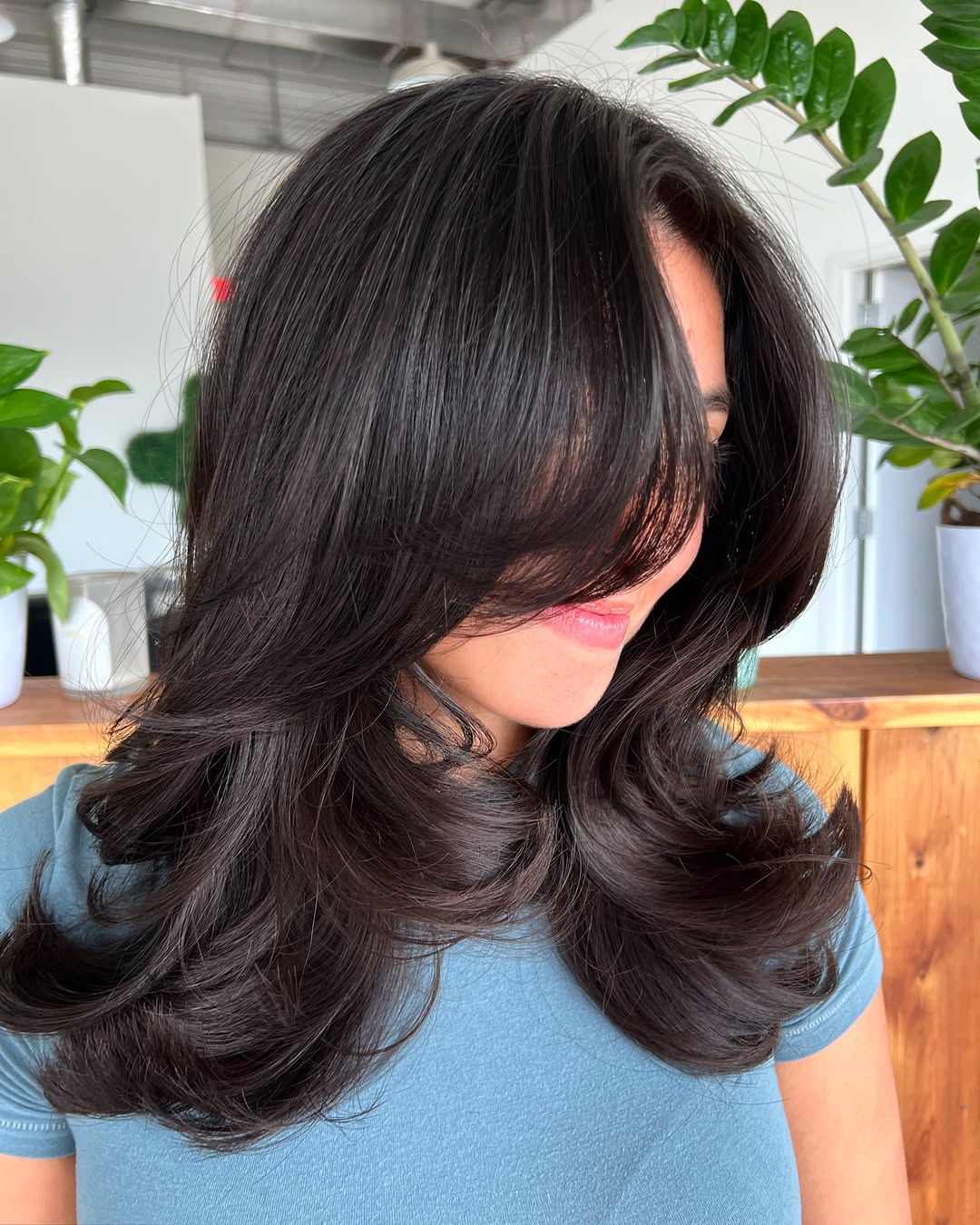 A woman with a sophisticated, layered bob with subtle highlights, a top flattering summer haircut 2026. Her hair frames her face perfectly for a sun-drenched day.