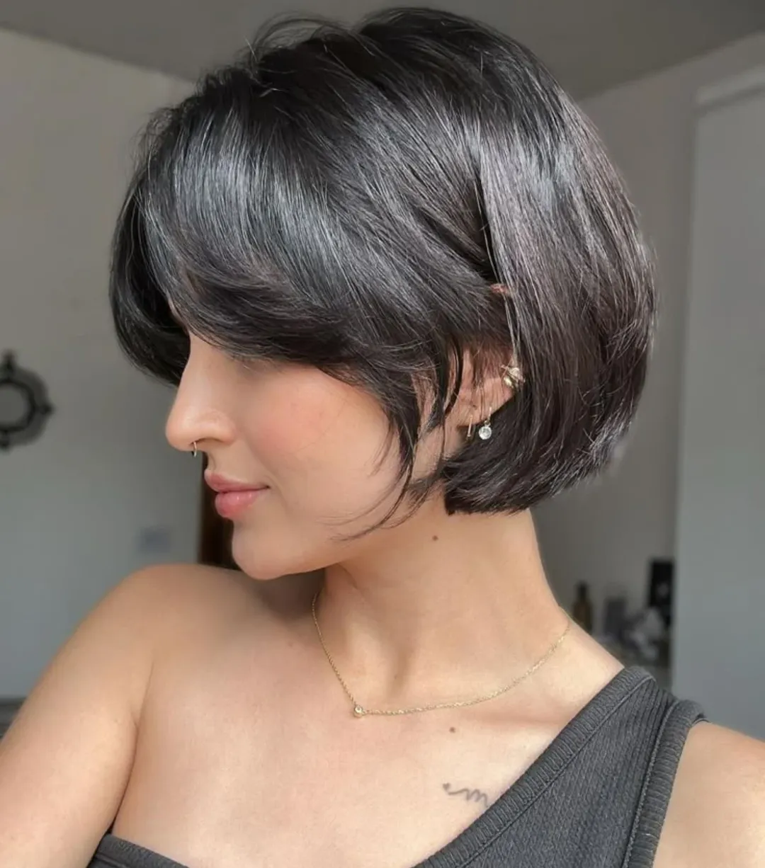 Close-up of a woman with a chic, layered bob haircut, perfect for flattering summer styles. Her hair is light brown with subtle highlights, framing her face beautifully, ideal for summer 2026.