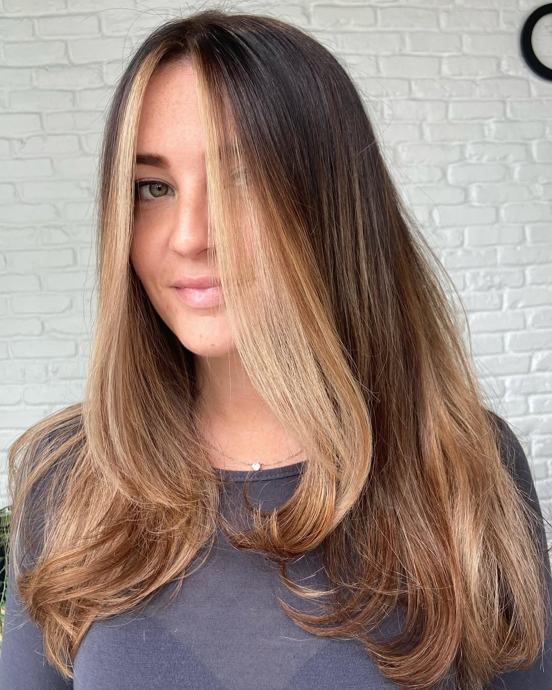 Close-up of a woman with a chic, shoulder-length bob haircut, styled with soft waves, perfect for flattering summer haircuts 2026. Her hair is a warm blonde, framing her face beautifully, ideal for summer.