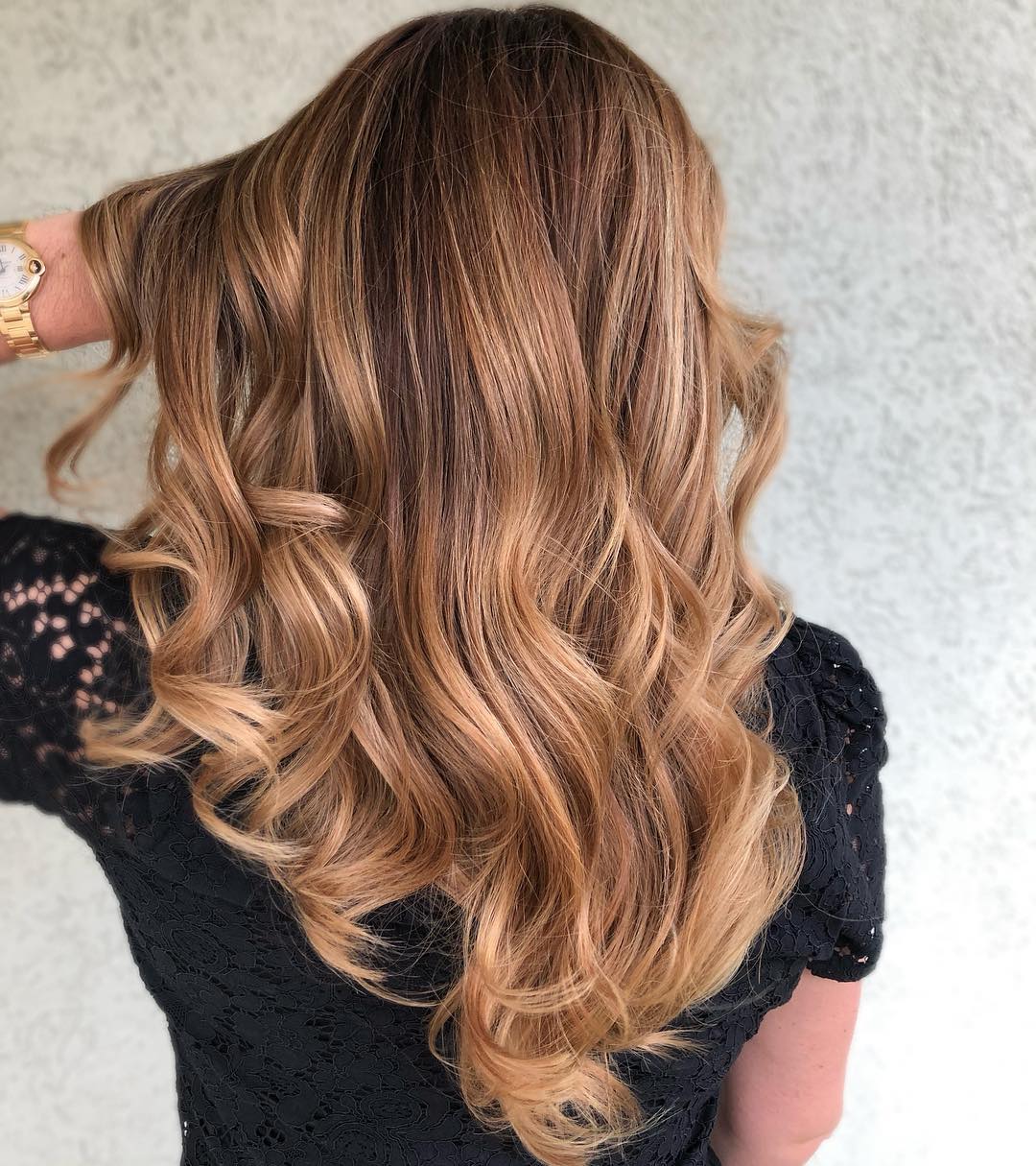 Close-up of a woman with golden balayage hair, styled in loose waves, wearing a delicate floral sundress, perfect for a day out in summer 2026.