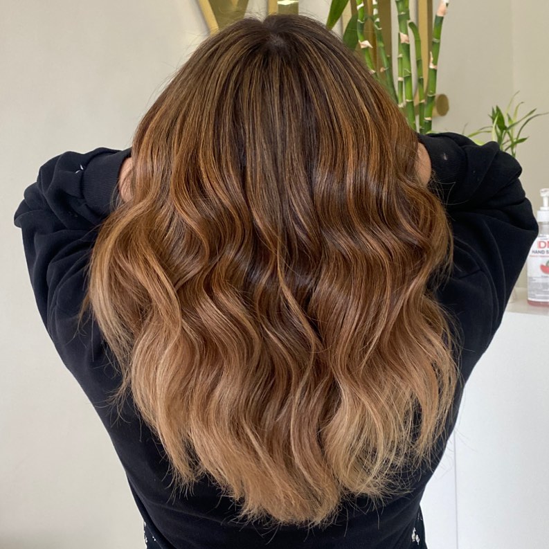 Woman with golden balayage summer 2026 hair wearing a white slip dress and espadrille wedges, perfect for a chic summer evening or vacation resort.