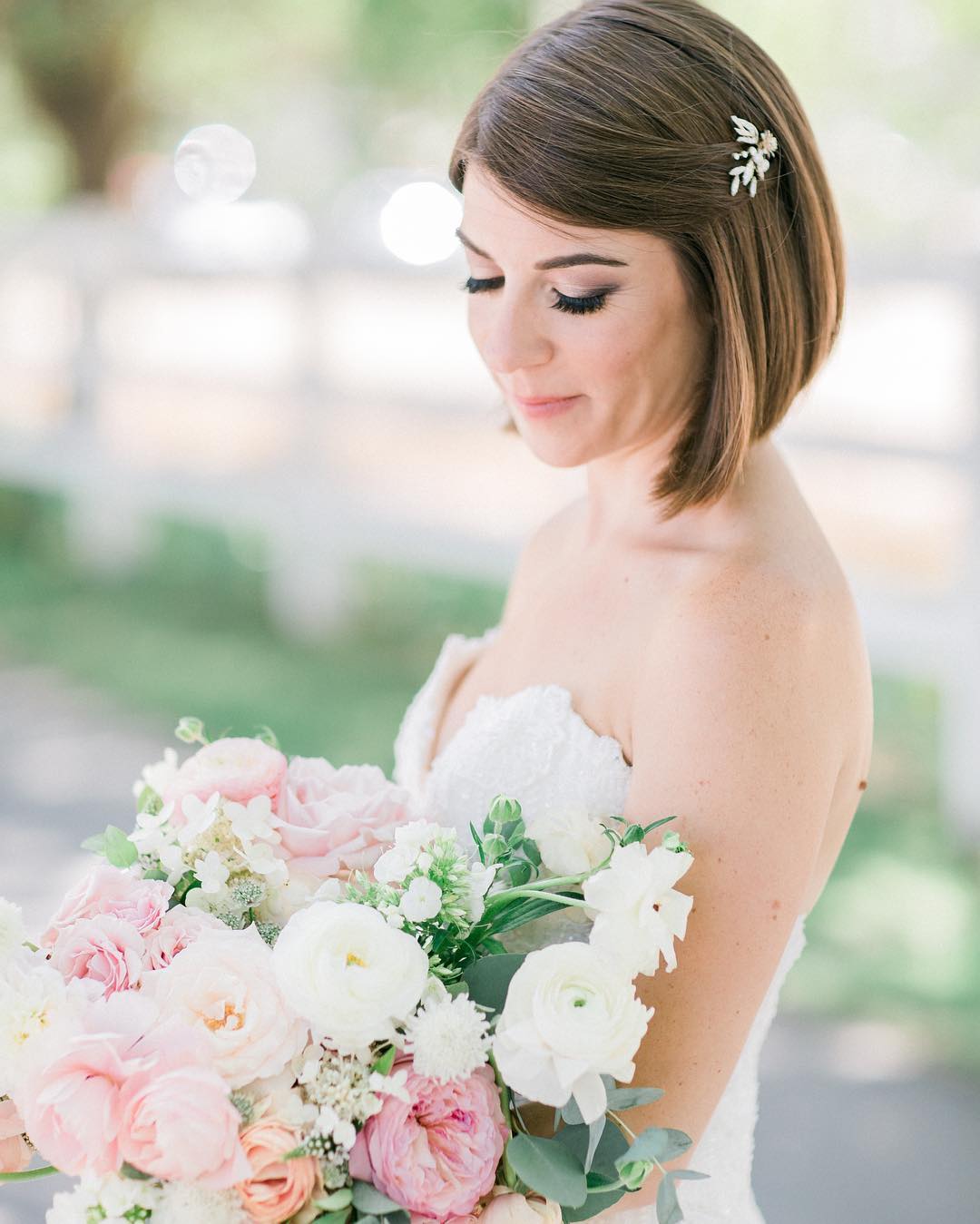 Beautiful blonde woman with a half-up twist and delicate floral pins, perfect outdoor wedding hair for summer 2026. This romantic style suits garden ceremonies.