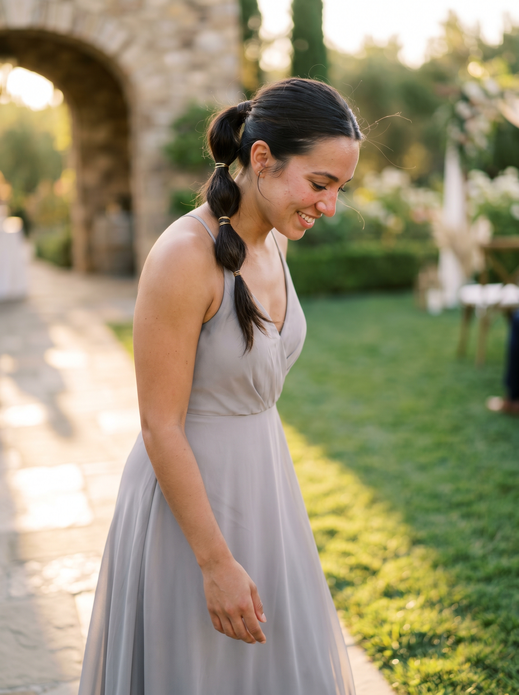 Chic minimalist bubble pony with gold hardware, a sleek option for outdoor wedding hair summer 2026. Features expensive brunette gloss with gold hair cuffs, styled with smoothing balm.