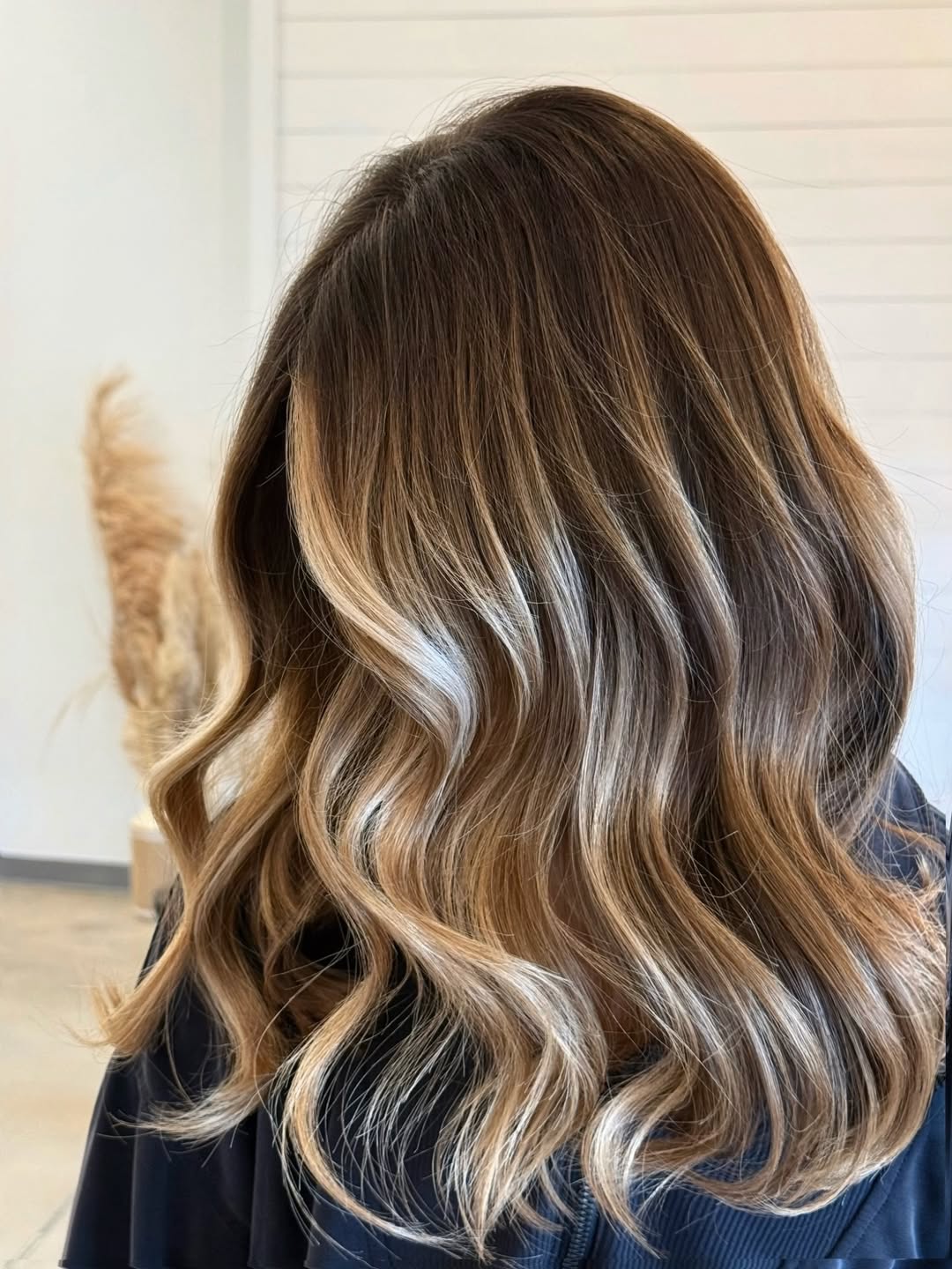 Close-up of a woman with stunning summer babylights balayage 2026, featuring golden blonde and sun-kissed highlights creating dimension around her face.
