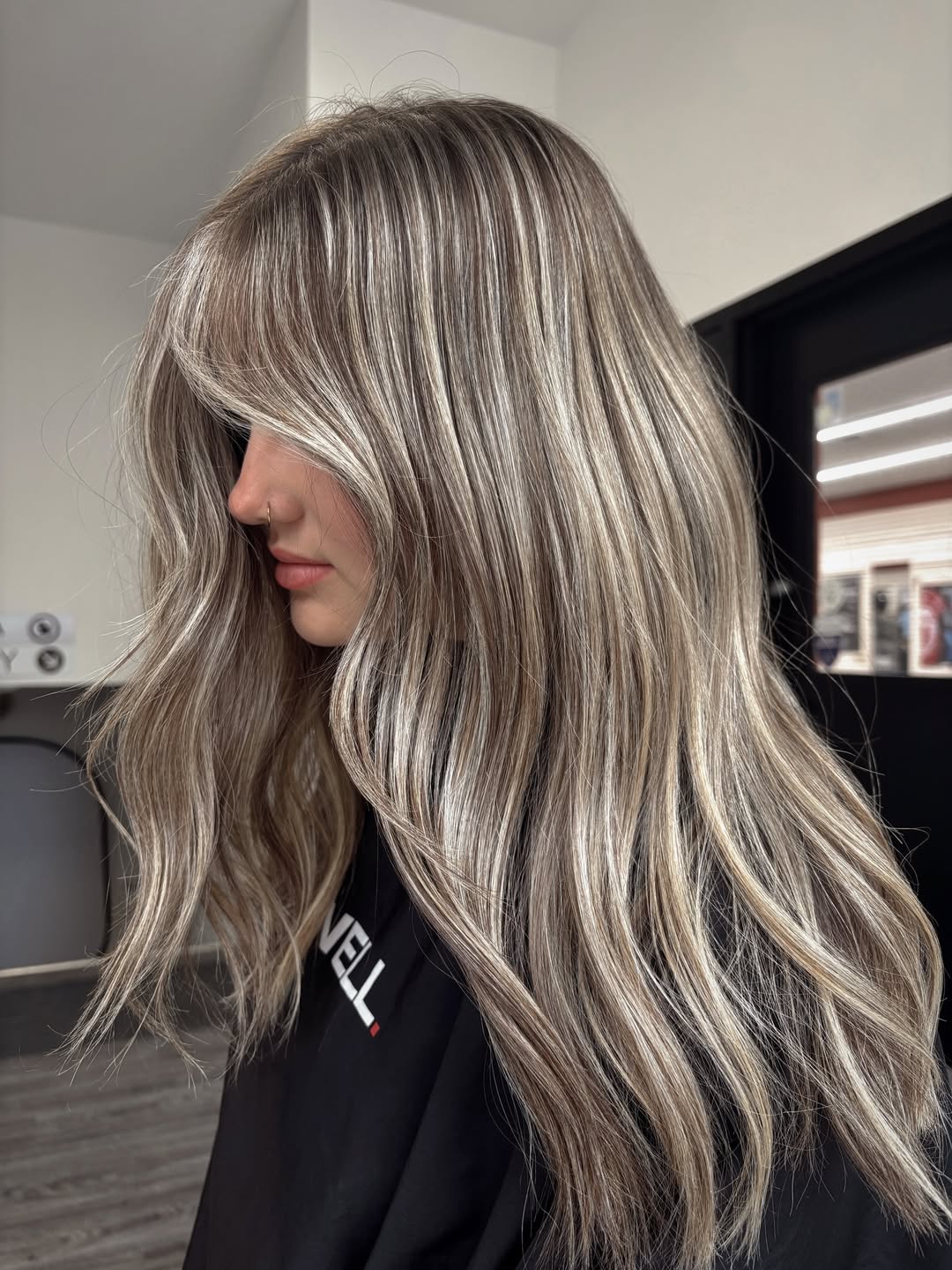 Close-up of a woman with long, wavy blonde hair showcasing beautiful summer babylights balayage 2026, perfectly blended and sun-kissed.
