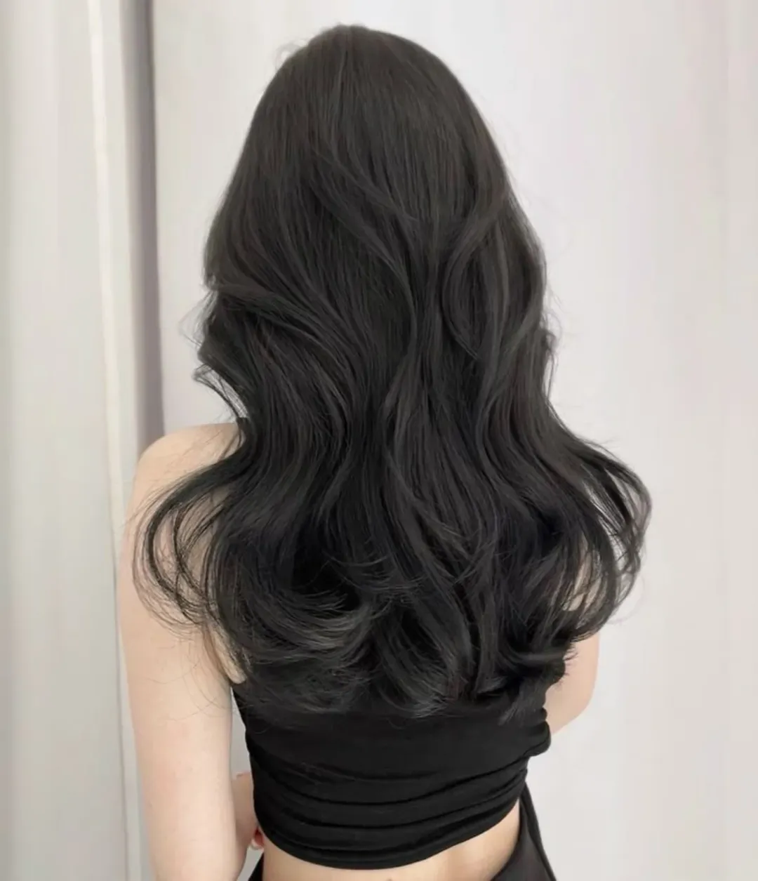 Beautiful woman with long, shiny auburn hair, showcasing a vibrant summer hair color option for 2026, styled with soft waves.
