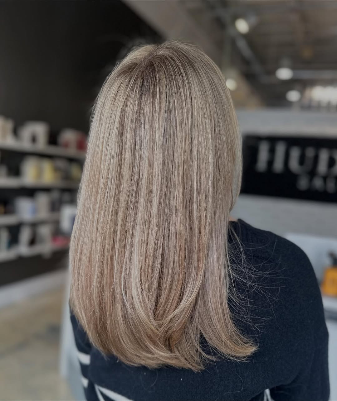 Beautiful woman with sun-kissed blonde balayage, a popular summer hair color option 2026, smiling outdoors.