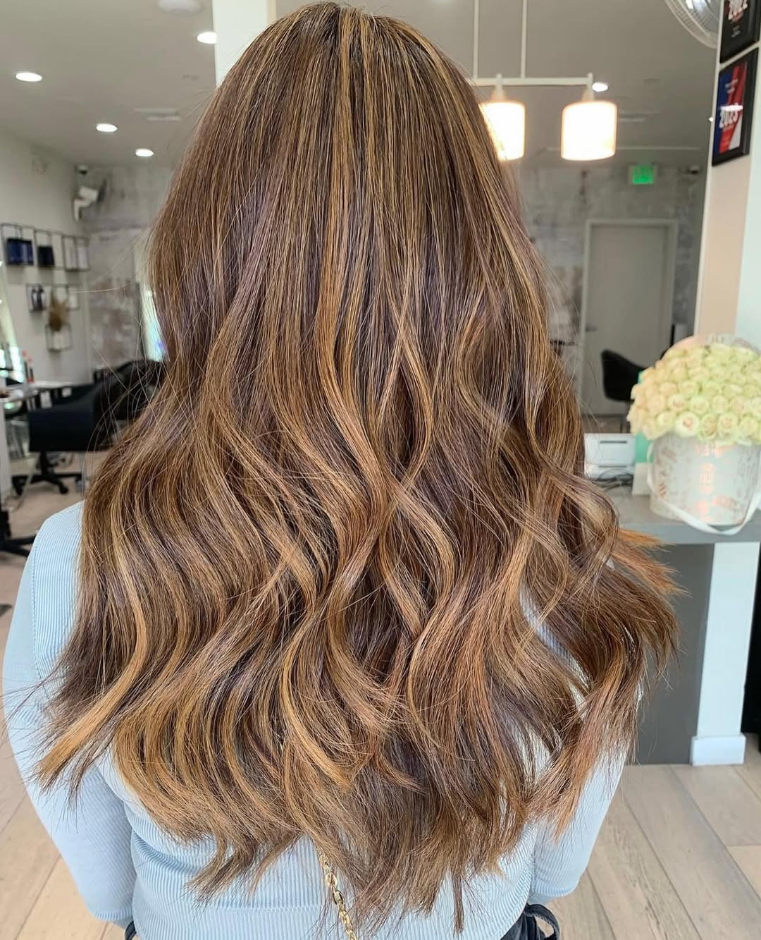 Close-up of a woman with vibrant copper balayage hair, showcasing one of the top summer hair color options 2026. Her sun-kissed strands highlight her complexion.