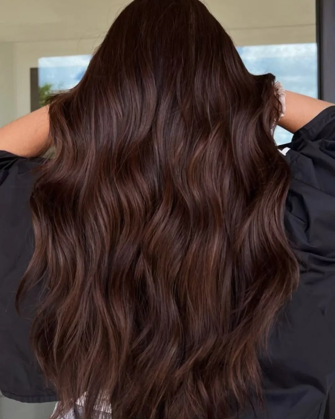 Close-up of a woman with vibrant copper-red hair, perfectly styled for summer hair color options 2026. Her hair is wavy and reflects sunlight, ideal for a bright, seasonal look.