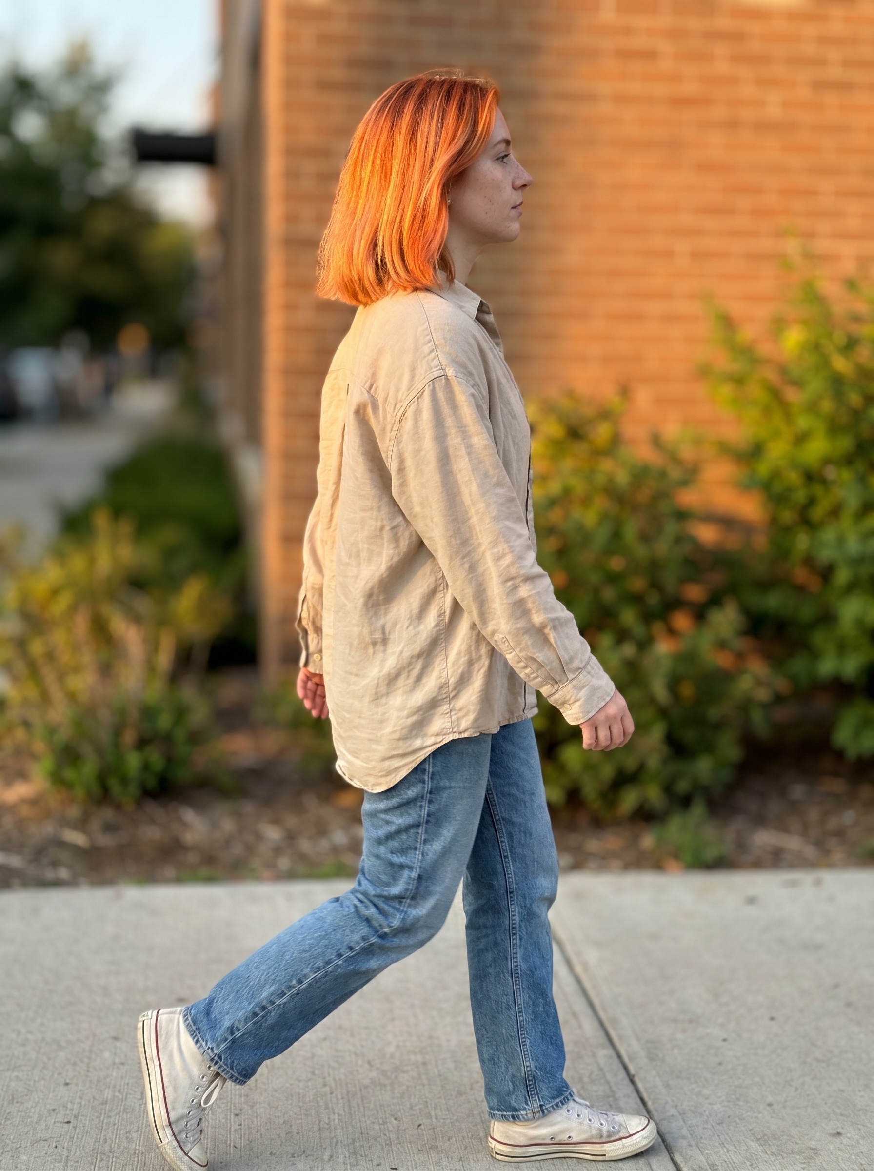 Sun-kissed Aperol Spritz Copper hair, a vibrant and playful summer hair color option 2026, showcasing bright orange, golden peach, and strawberry blonde hues.