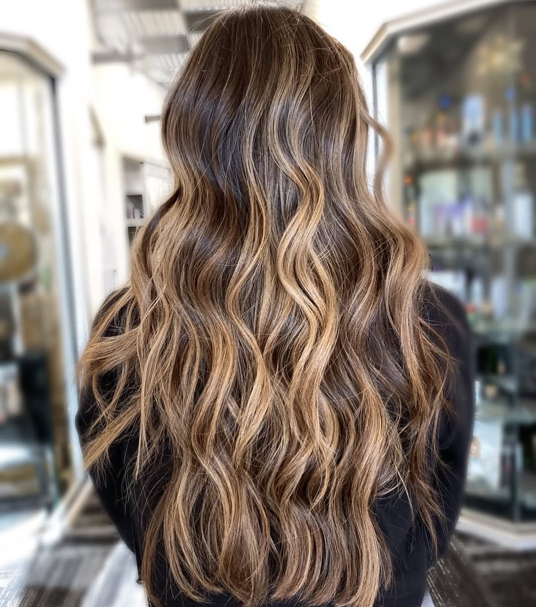 Close-up of a woman with vibrant, sun-kissed blonde summer hair color options 2026, styled in soft waves, suitable for beach days.