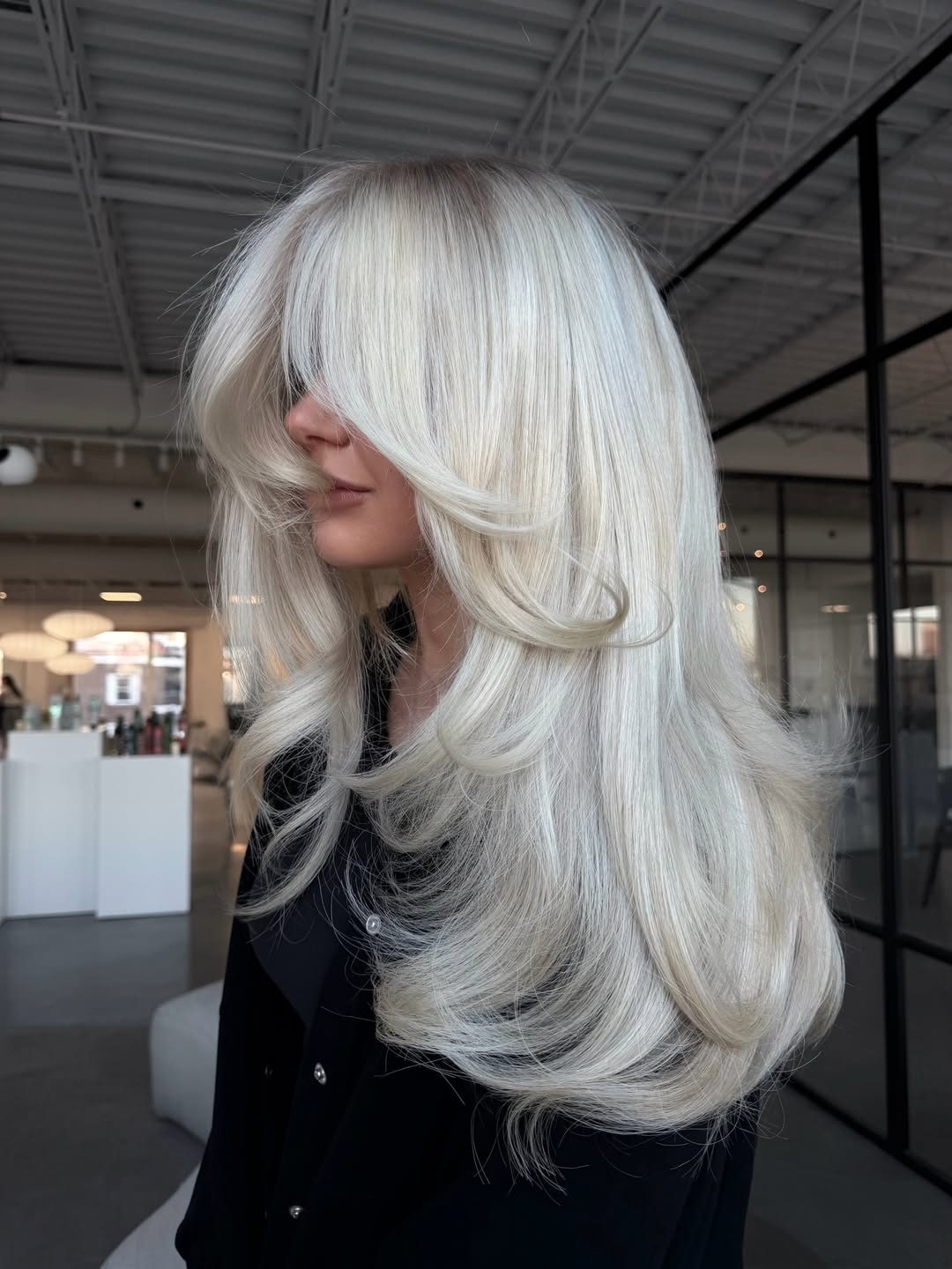 A woman with vibrant summer hair ideas for blondes 2024, featuring a chic braided updo with sun-kissed highlights, perfect for a casual outdoor brunch.