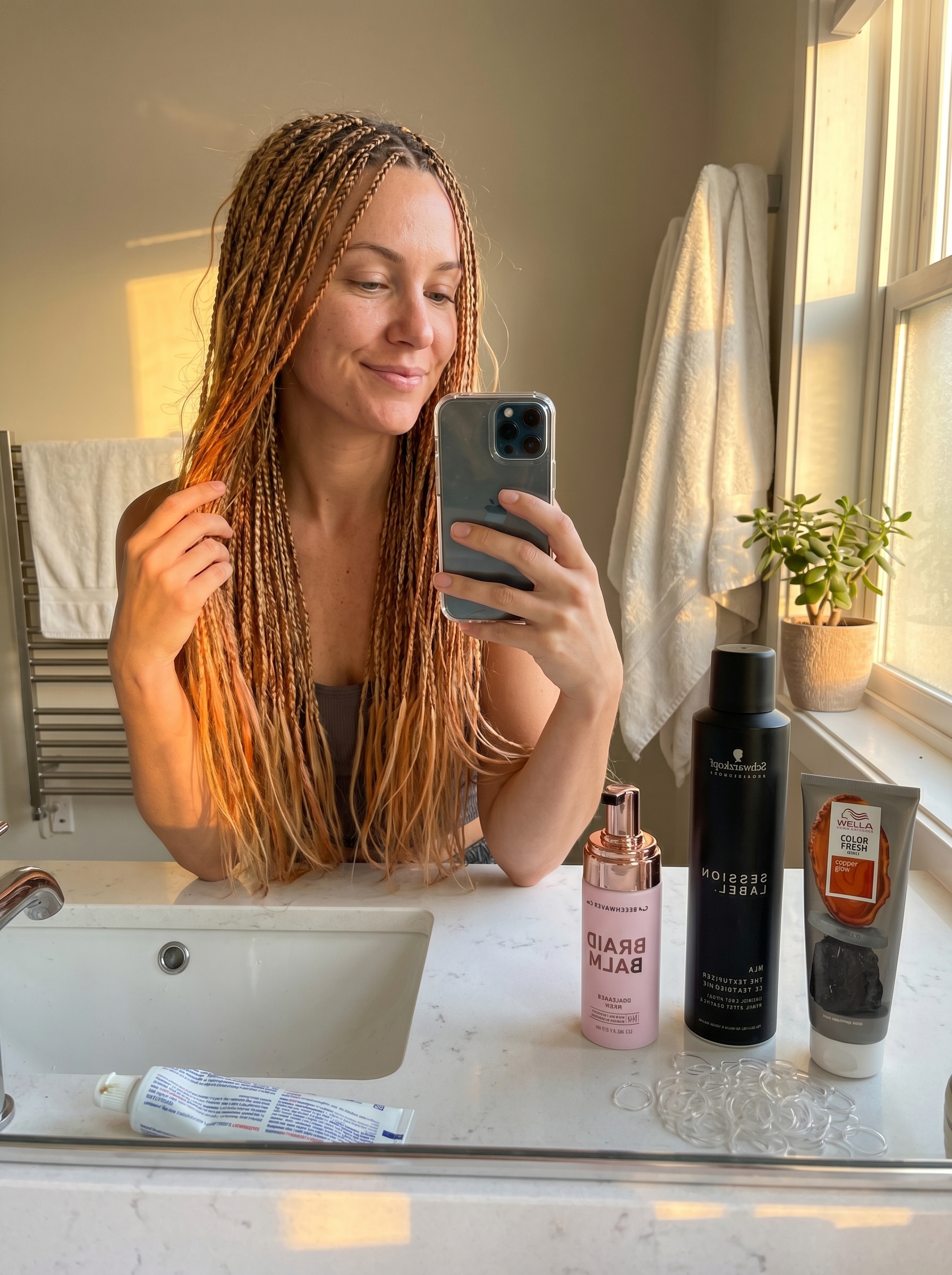 Romantic apricot crush highlighted baby braids on light blonde hair, featuring subtle copper tones. A whimsical and ethereal idea for summer hair ideas for blondes.