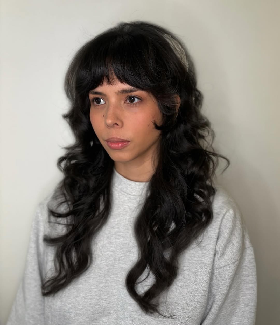 A woman with a chic, sun-kissed blonde lob haircut, perfect for summer haircuts inspiration 2026. This modern cut features subtle layers framing her face.