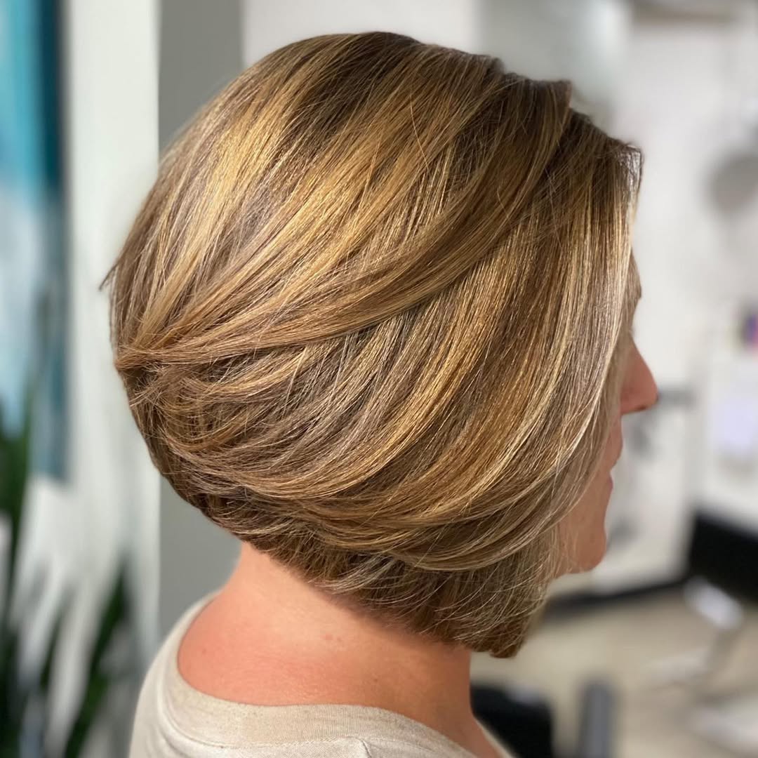 Blonde woman with a chic, choppy bob haircut with subtle waves, perfect for summer haircuts inspiration 2026. Her hair is short, framing her face beautifully, ideal for warm weather.
