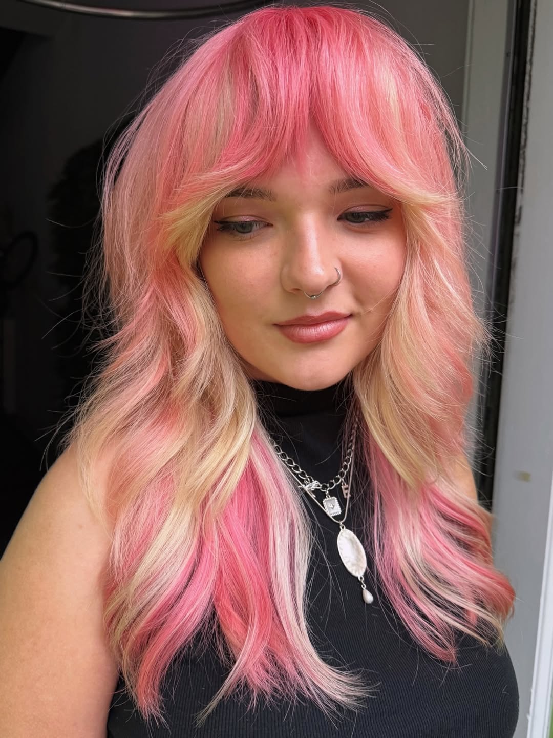 Close-up of a woman with a trendy, layered bob haircut, perfect for summer haircuts inspiration 2026. Her dark hair has subtle highlights.
