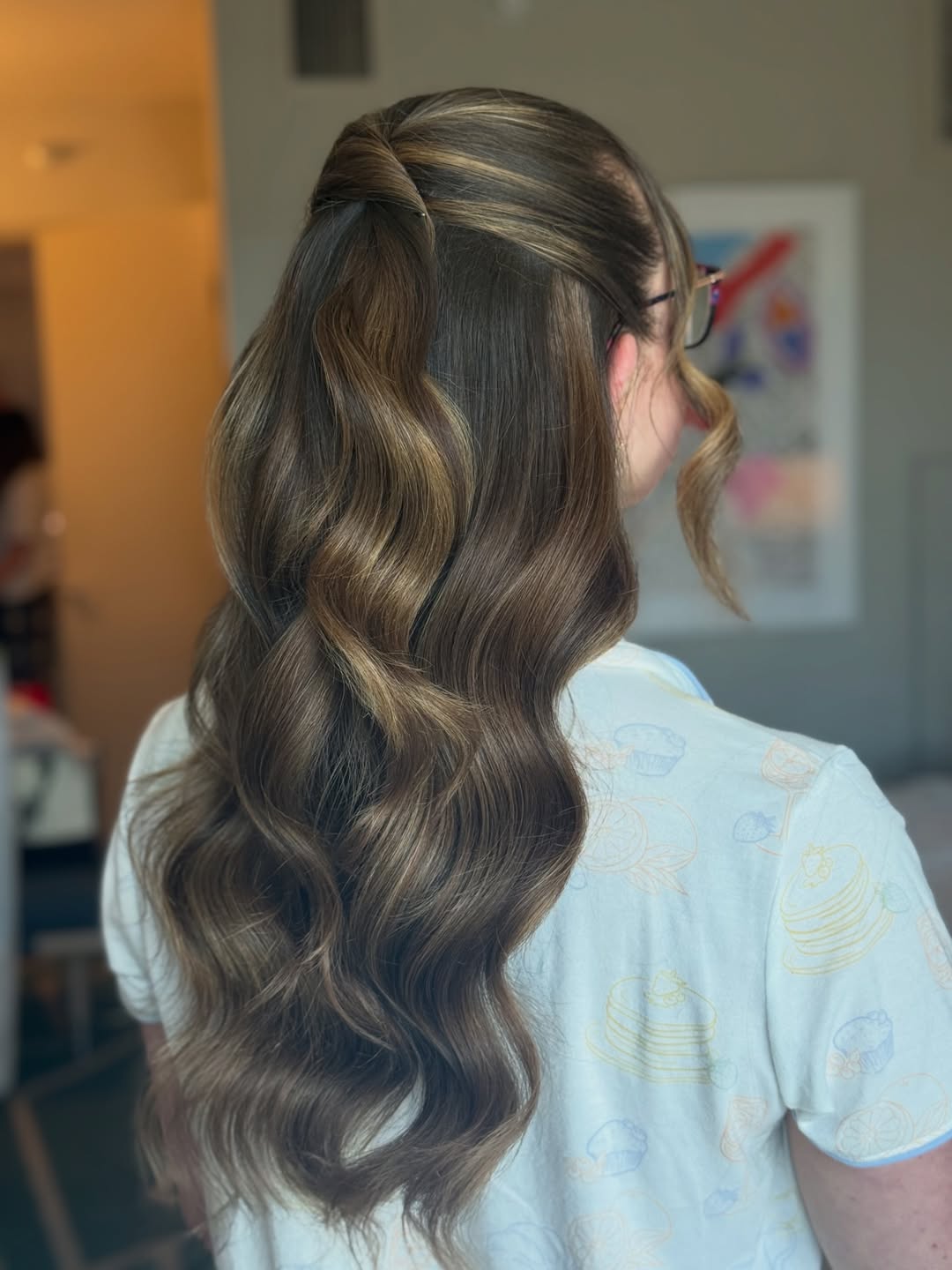 Close-up of a woman with long, sun-kissed blonde hair styled in loose beach waves, perfect for top summer hairstyles 2026. Her hair has subtle highlights framing her face, creating a soft, natural look.
