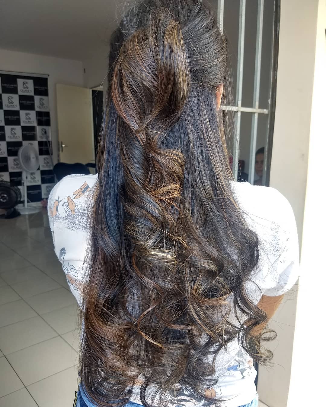 A woman with perfectly styled top summer hairstyles 2026, featuring a relaxed bouncy blow dry with face-framing layers in a sandy blonde shade, ideal for a chic everyday look.