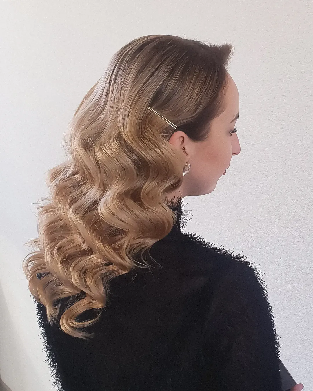 Close-up of a woman with a sleek, high ponytail, styled with a sophisticated braid and gold hair accessories, perfect for chic top summer hairstyles 2026.