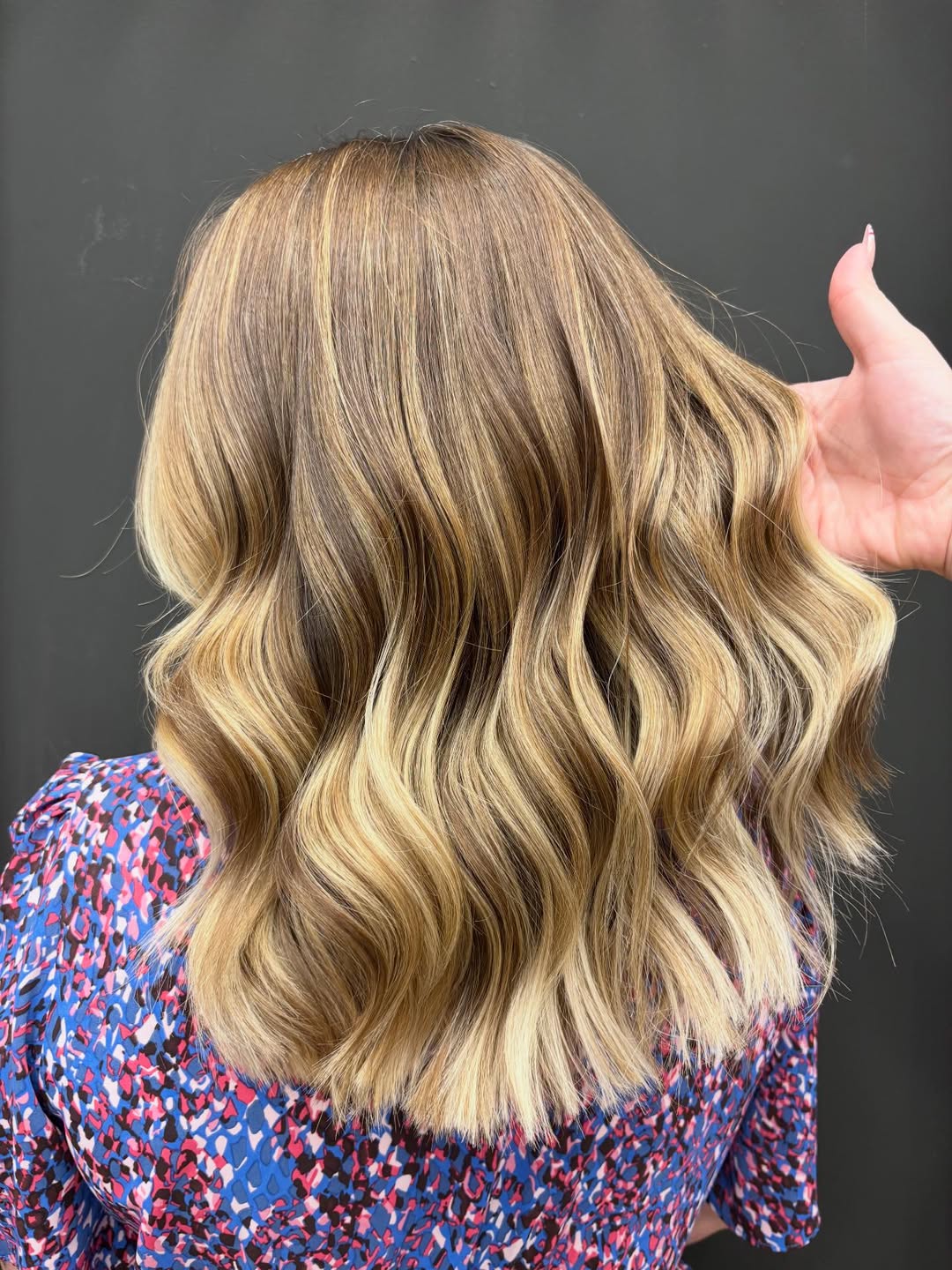 A woman confidently holds her hair, showcasing a chic braided updo, perfect for enduring the heat while embracing top summer hairstyles 2026. The intricate braids offer both style and practicality.
