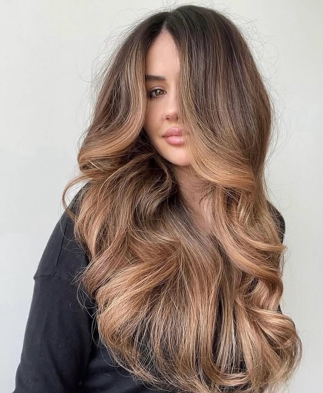 Blonde woman with sun-kissed hair styling a chic, layered bob for summer 2026. Perfect smart casual look with light makeup.