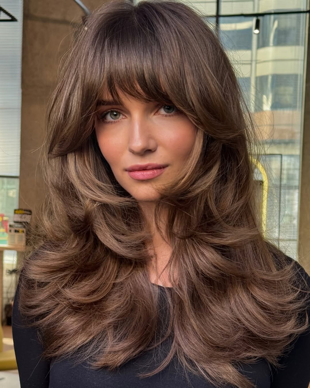 Beautiful woman with a chic, layered bob haircut, perfect for women haircuts summer 2026. Her blonde hair frames her face, ideal for a casual day out.