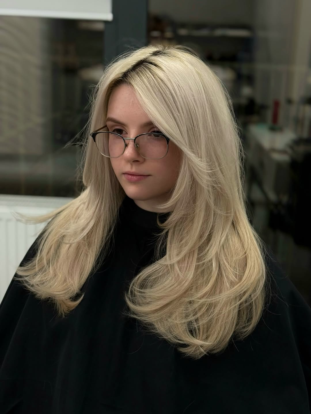 A woman with a sun-kissed blonde long bob, styled with soft waves, showcasing a popular women haircuts summer 2026 trend. She wears a casual white sundress, perfect for a beach day or vacation.
