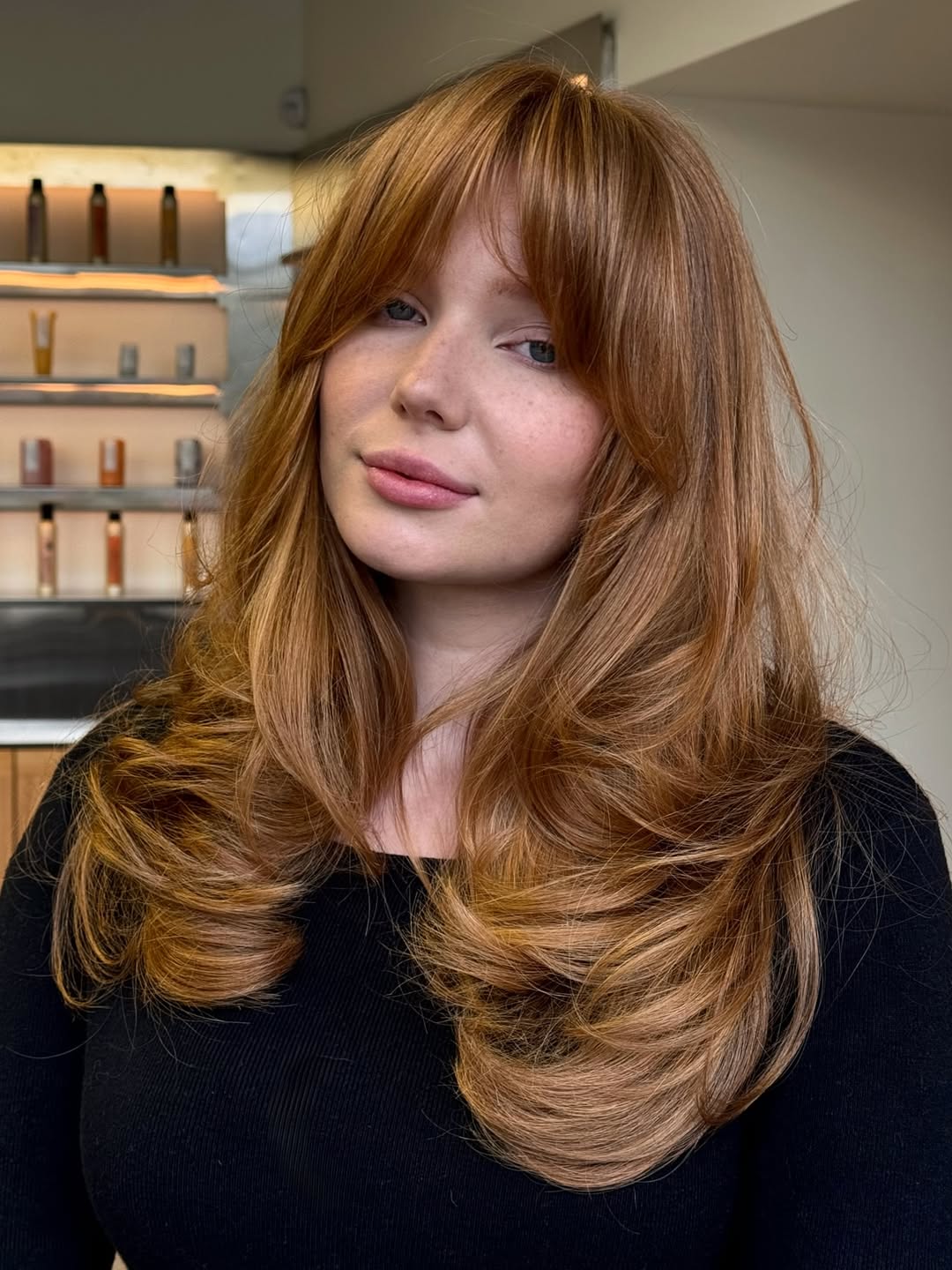 Close-up of a woman with a sleek, chin-length blonde bob haircut styled with loose waves, ideal for women haircuts summer 2026. Perfect for a chic, breezy summer look.