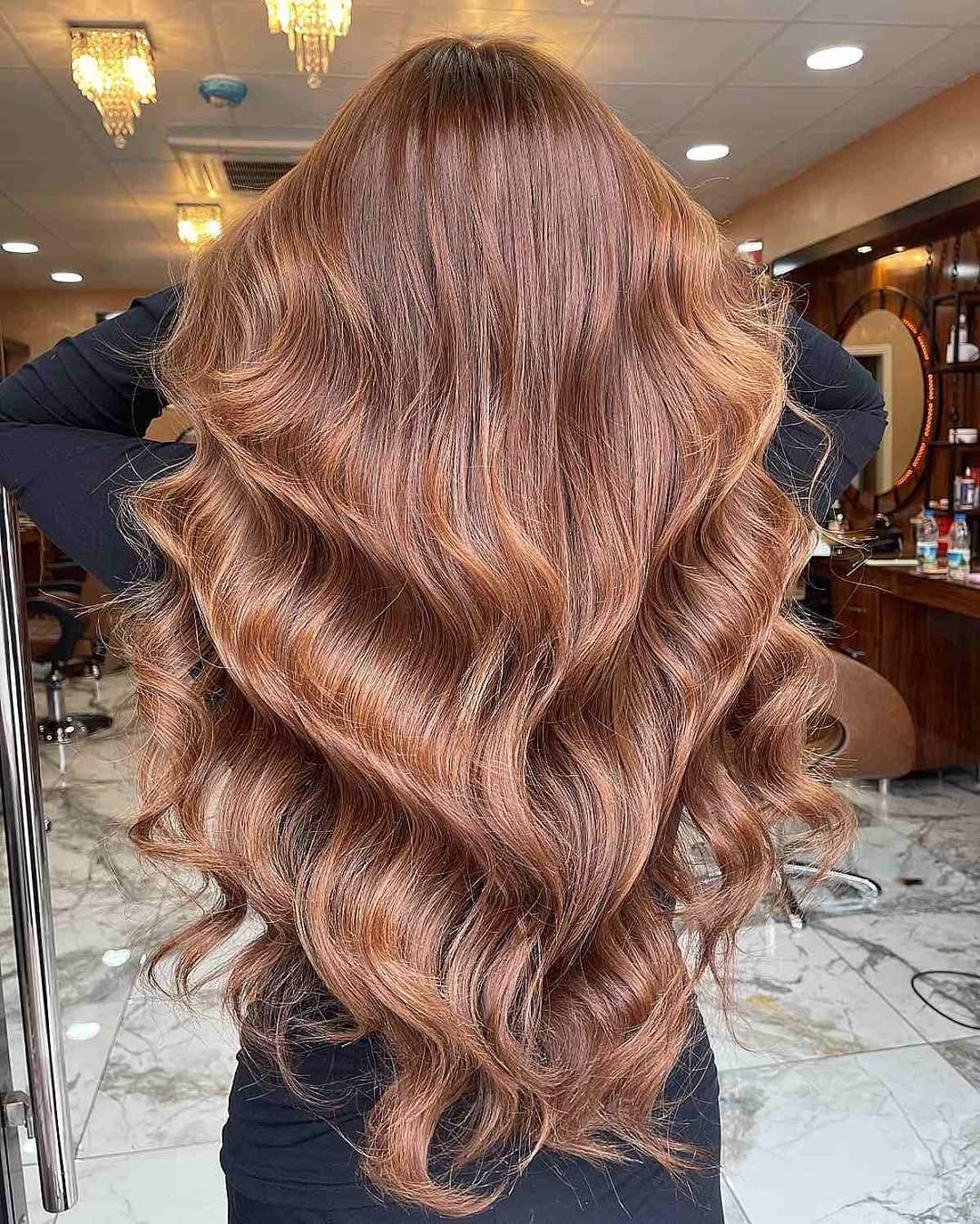 Chic Caramel Brown Summer Hair 2026 Styles Woman with long, wavy caramel brown summer hair 2026 styled in a chic, effortless look, wearing a white off-the-shoulder top.