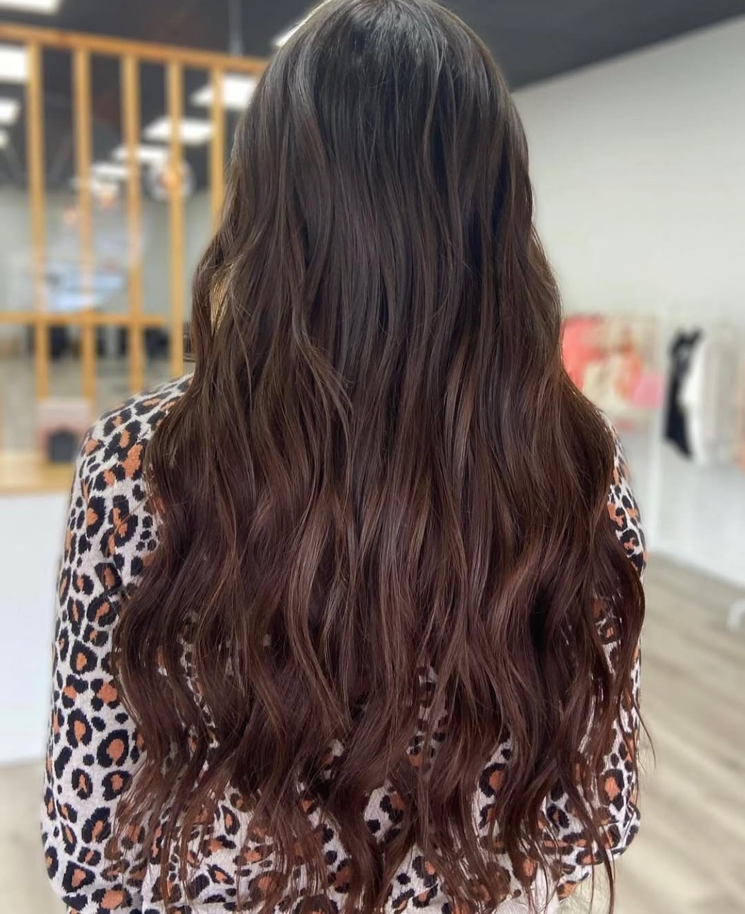 Stunning Chocolate Brown Summer Hair 2026 Trends Close-up of a woman with glowing, deep chocolate brown summer hair 2026, styled in soft waves framing her face. She wears a golden-toned top, perfect for a sunny day.