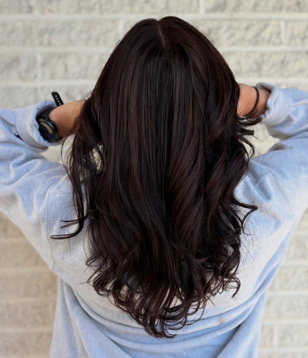Chic Wavy Chocolate Brown Summer Hair 2026 Looks A woman with glowing chocolate brown summer hair 2026, styled in soft waves, against a bright, sunny background, perfect for a chic daytime look.