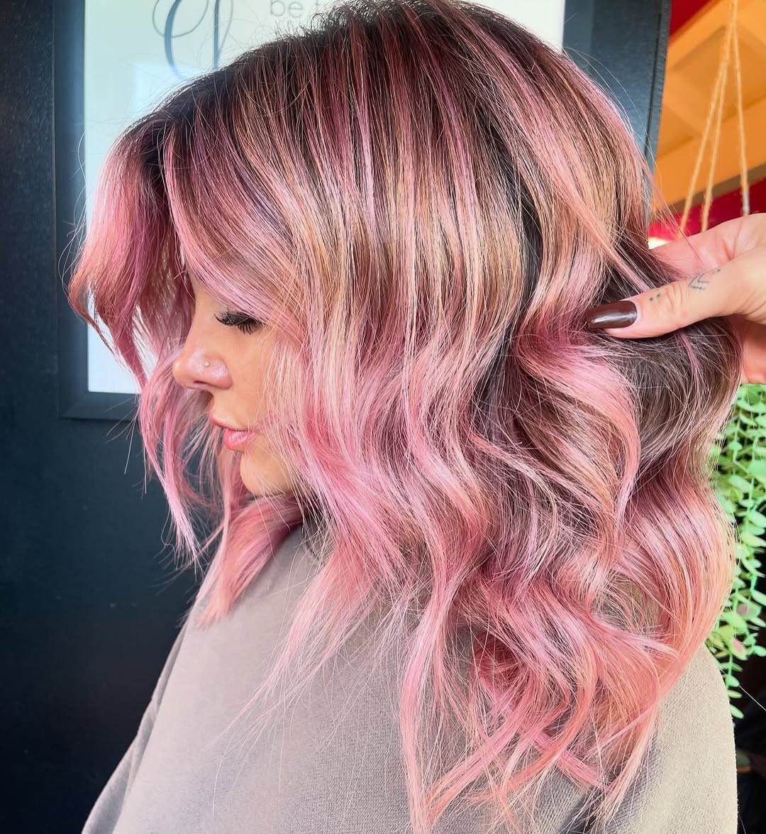 Close-up of a woman with vibrant pastel purple and pink hair, styled in loose waves, showcasing the trendy pastel hair color summer 2026 for a playful, sunny look.