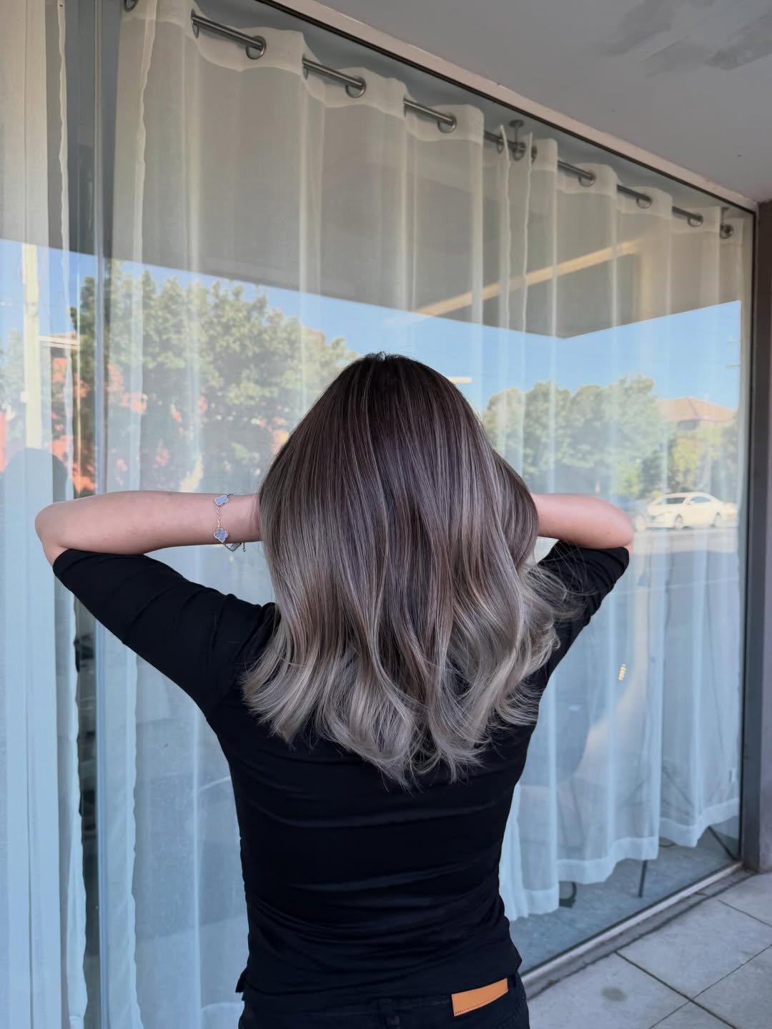 Close-up of a woman with cool-toned ash brown hair demonstrating a soft summer palette hair 2026. Her hair has subtle, natural lowlights.