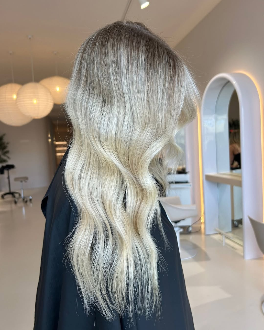Close-up of a woman with soft summer palette hair 2026, featuring subtle blonde highlights and cool undertones framing her face for a natural look.