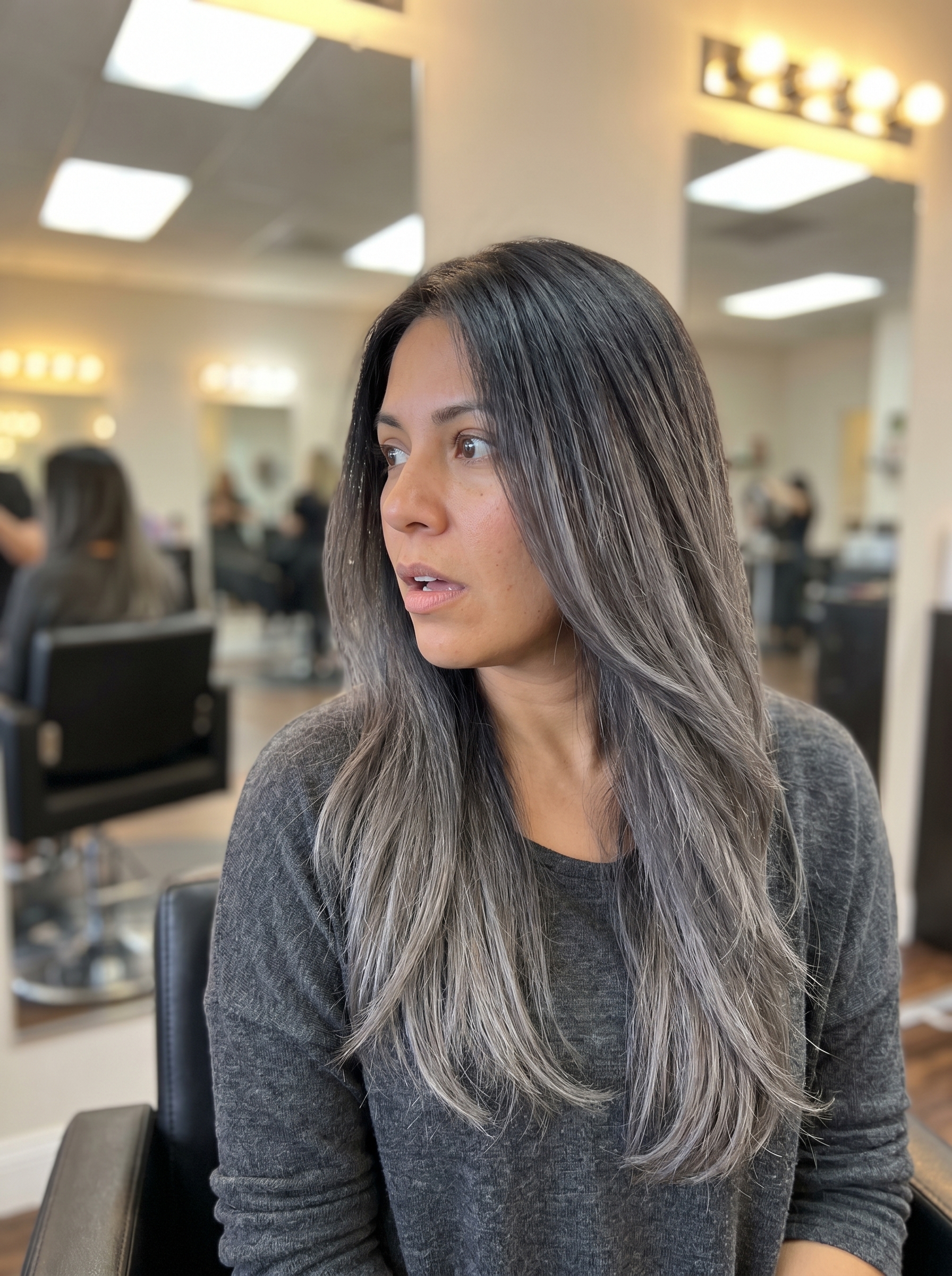 This edgy Soft Charcoal Ombre hair showcases the soft summer palette hair 2026 trend. Features deep charcoal roots blending to ash grey and silver mist ends, perfectly neutralized with purple shampoo for a modern, dramatic effect.