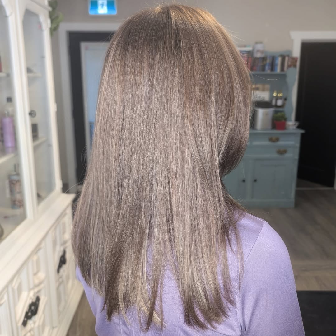 Close-up of a woman with warm blonde hair highlighting a soft summer palette hair 2026, showcasing gentle, sun-kissed dimension and natural waves.