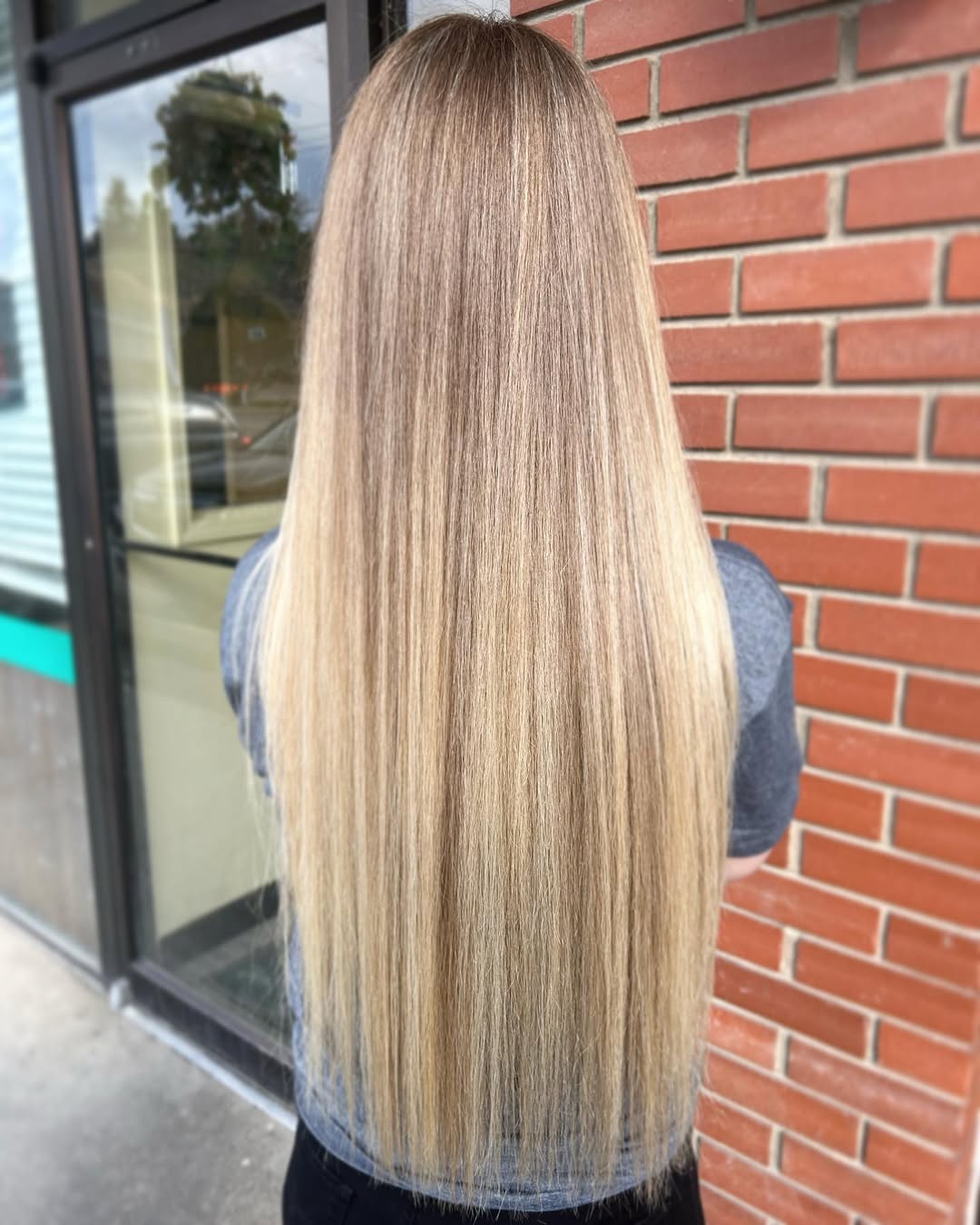 A woman with naturally wavy, medium brown hair featuring subtle, cool-toned highlights, perfect for the soft summer palette hair 2026 trend. Her hair frames a gentle, refined makeup look.