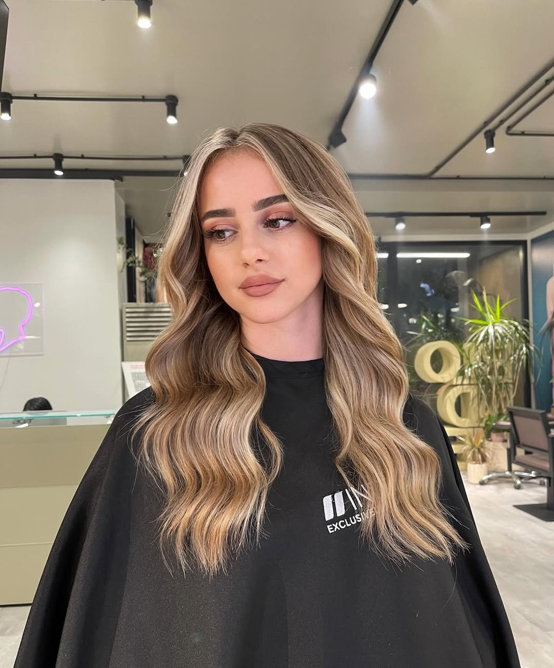 Close-up of a woman with radiant, sun-kissed subtle highlights summer hair 2026, showing soft caramel and honey tones blending seamlessly into her brunette base.