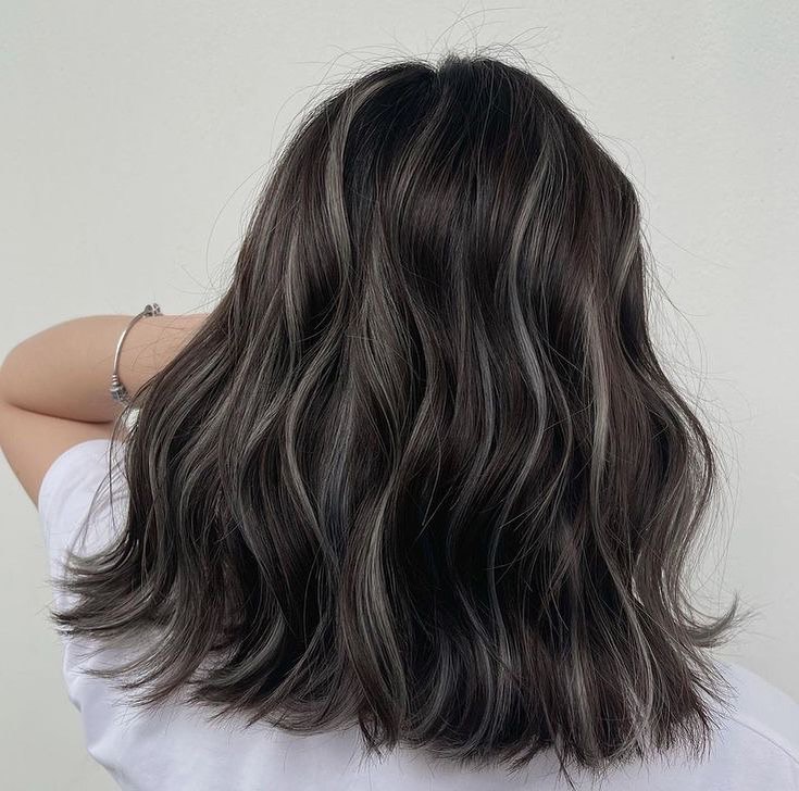 Close-up of a woman smiling with natural-looking caramel and honey blonde subtle highlights for summer hair 2026, styled in soft waves.