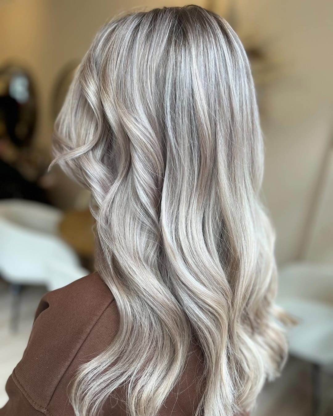 Close-up of a woman with natural looking subtle highlights summer hair 2026, featuring sun-kissed streaks on light brown strands.