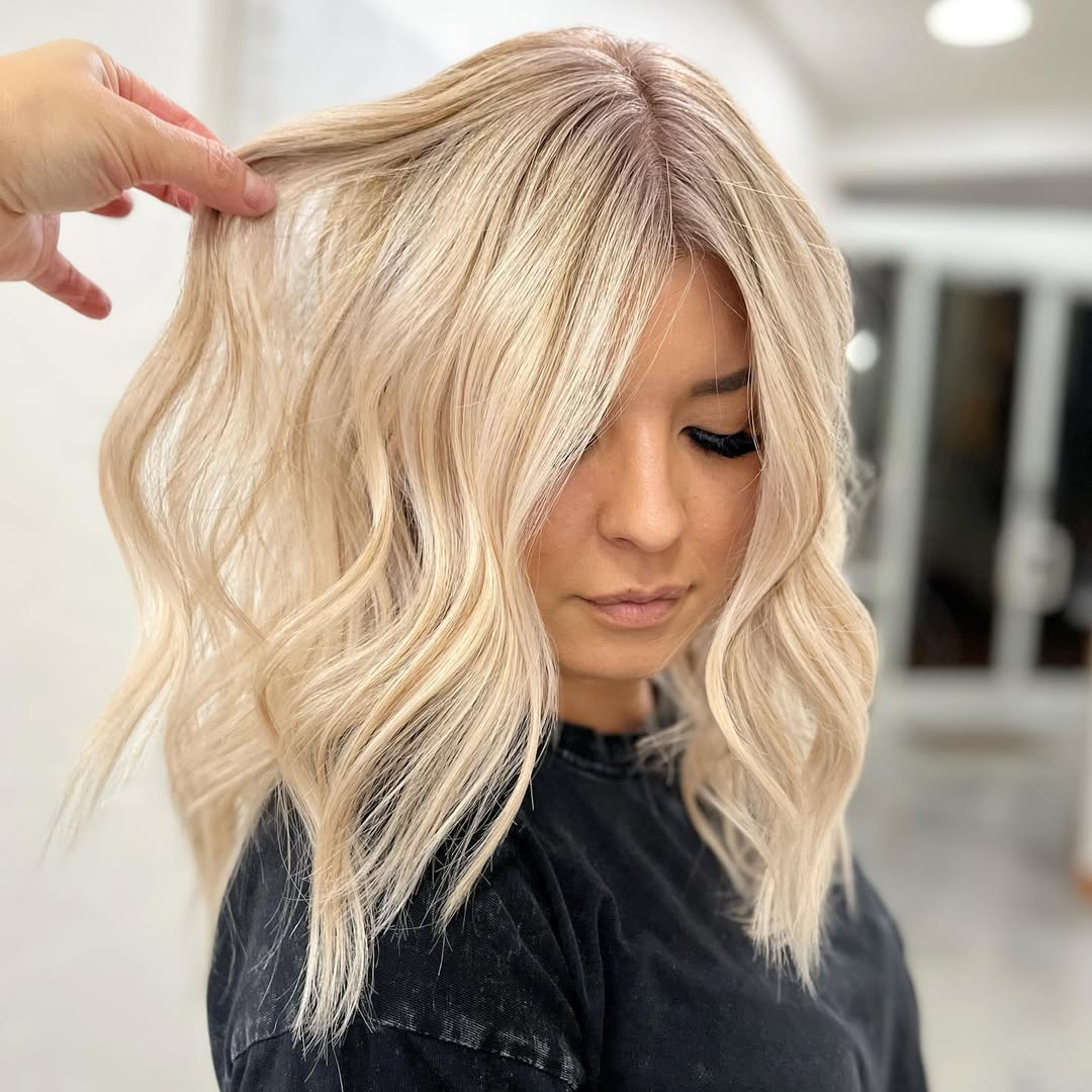Stunning Summer Beachy Waves Hair 2026 Look Close-up of a woman with beautiful, voluminous summer beachy waves hair 2026, highlighted with golden blonde tones, smiling softly.