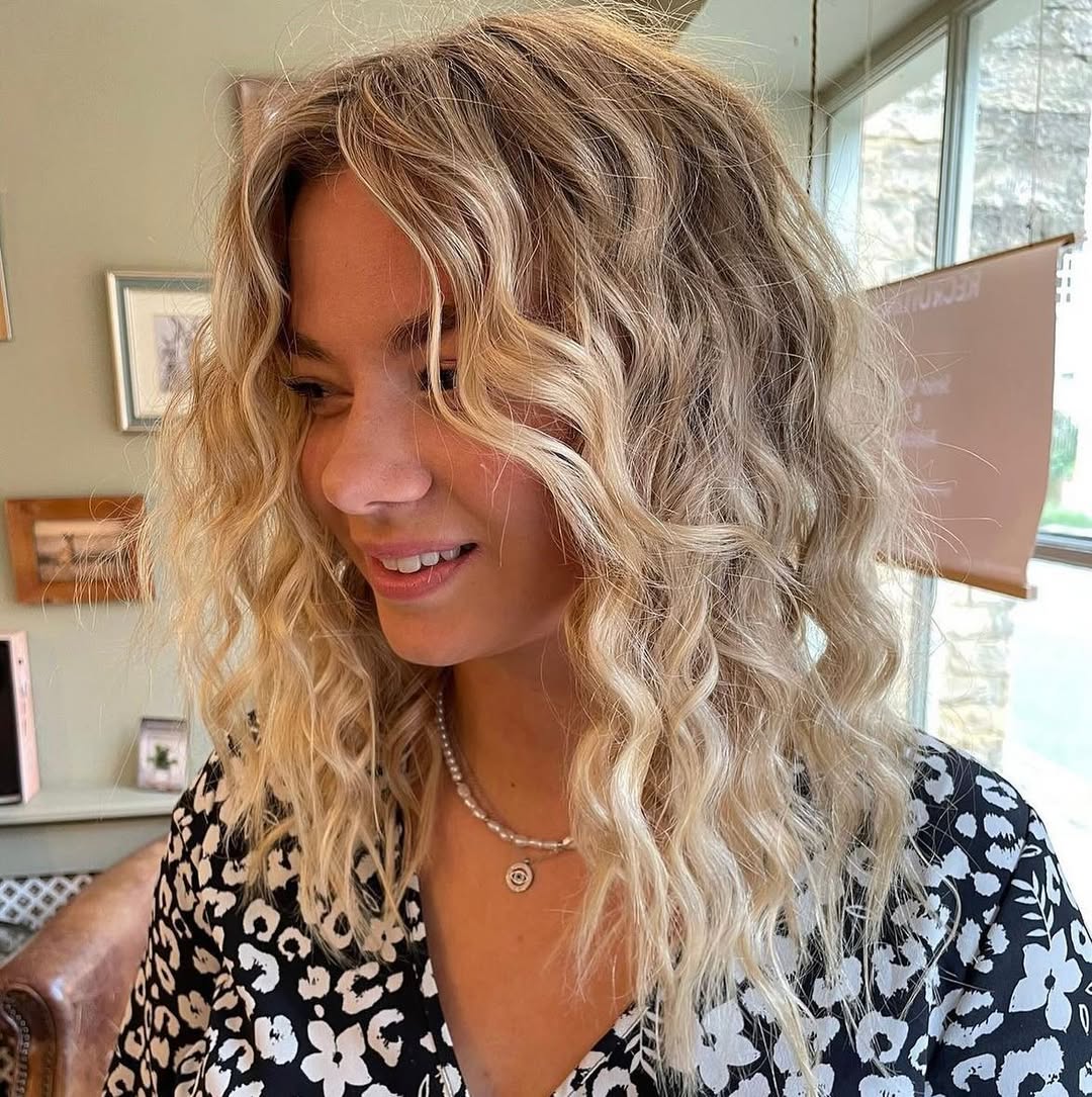 Effortless Summer Beachy Waves Hair 2026 Close-up of a woman with naturally styled summer beachy waves hair, highlighting sun-kissed blonde tones for a relaxed vacation look.