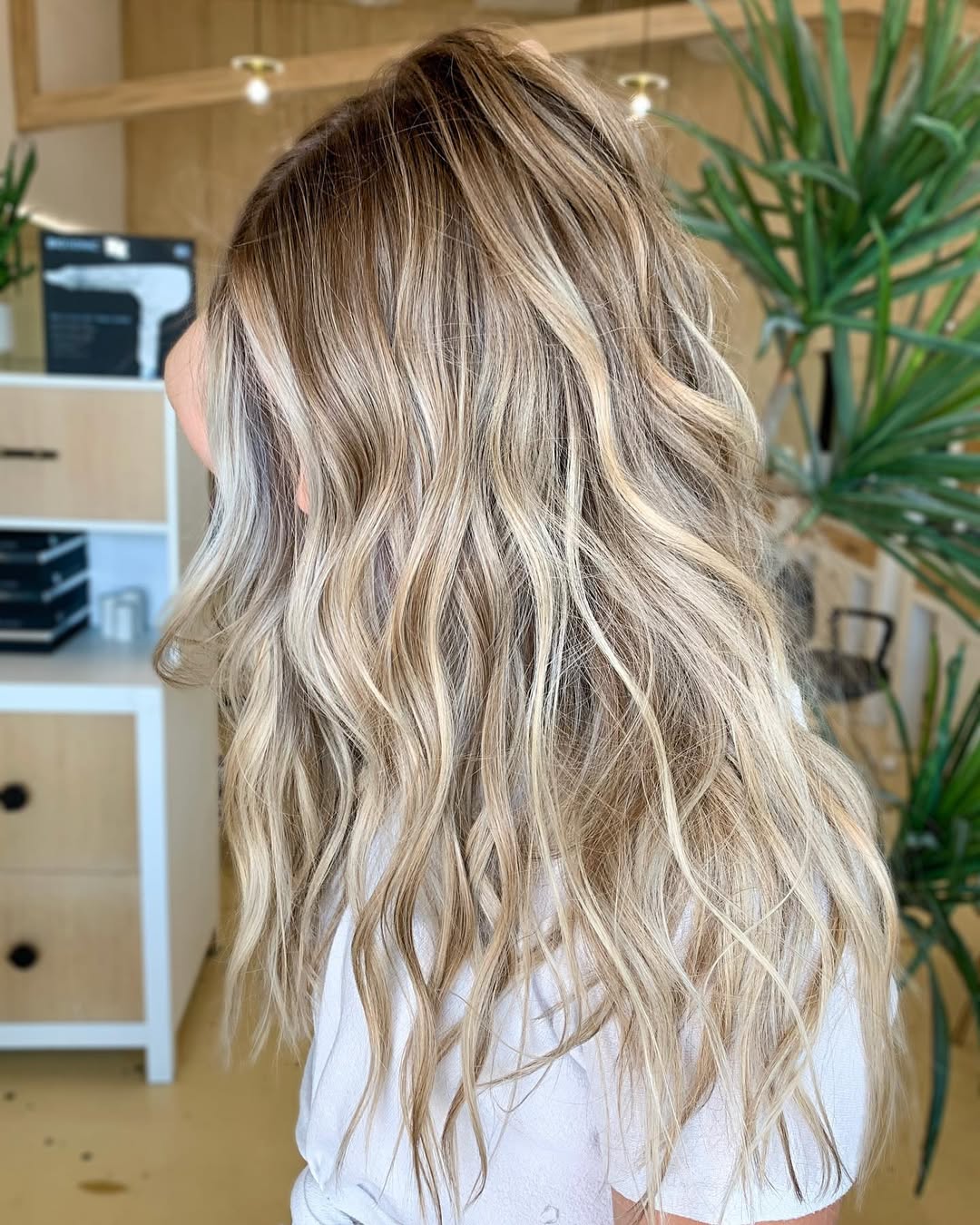 Achieve Perfect Summer Beachy Waves Hair 2026 Look Close-up of a woman with sun-kissed blonde hair styled in soft, natural summer beachy waves hair 2026, catching the light. Perfect for a casual day out.