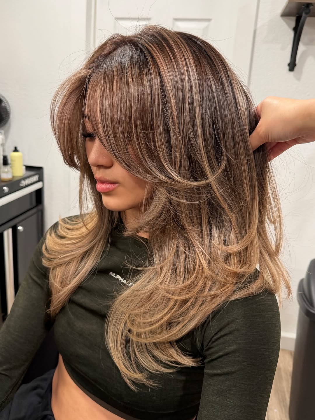 Close-up of a woman with vibrant, sun-kissed strawberry blonde hair, perfect for summer hair color cute ideas 2026. The hair is styled in loose, beachy waves.