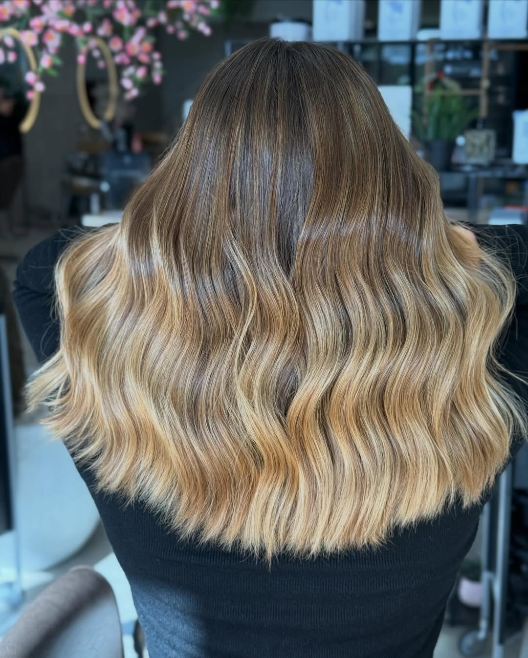 Close-up of a woman with vibrant copper-red hair styled in loose waves, showcasing a beautiful summer hair color cute idea. Her hair glows in the sun, perfect for a chic summer look.