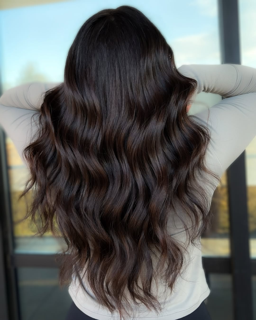 Stunning Summer Hair for Brunettes 2026: Beach Waves Beautiful brunette woman with flowing, wavy summer hair for brunettes 2026, styled casually for a beach day or vacation.