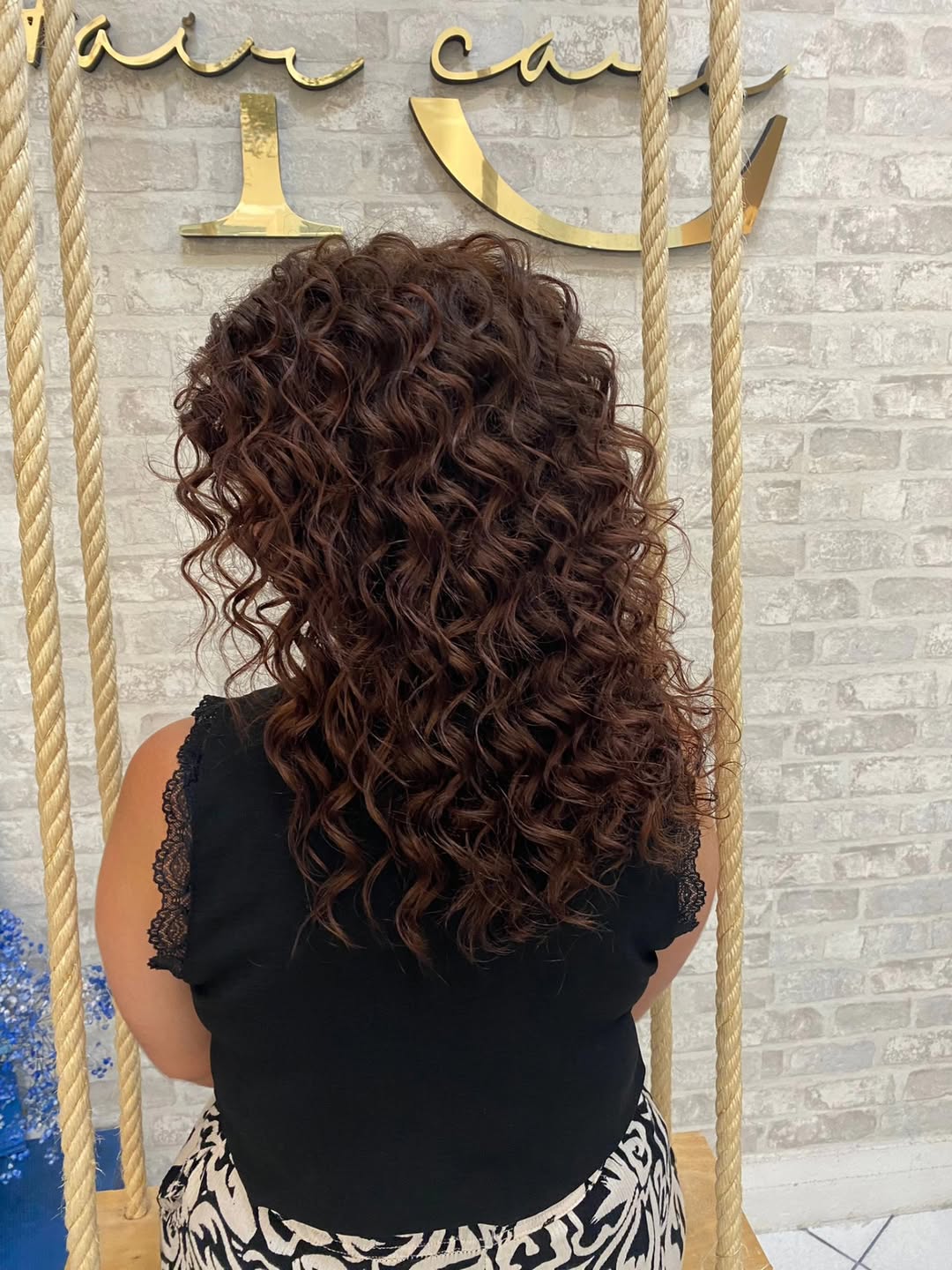 Stunning Summer Hair for Brunettes 2026: Wavy & Effortless A woman with cascading wavy summer hair for brunettes styled with loose curls and subtle highlights, perfect for a casual sunny day look.